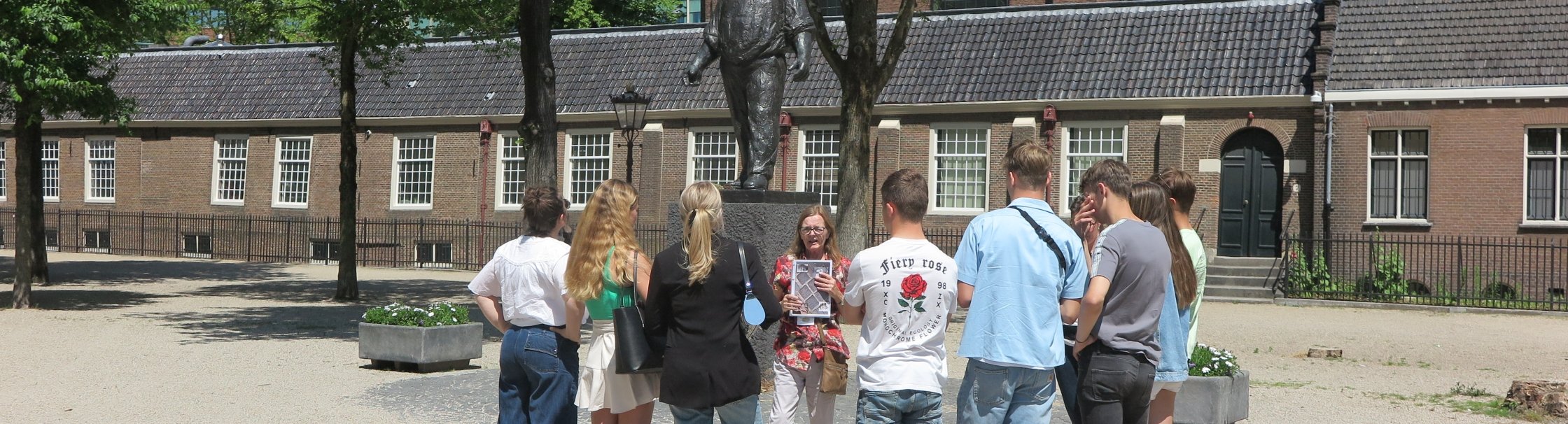 Een museumdocent vertelt tijdens een buurtwandeling over de Hollandsche Schouwburg.