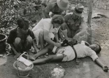 Nederlandse verpleegster verzorgt een Indonesisch slachtoffer. Batavia, West-Java, november 1945.
