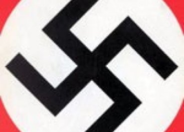 Massabijeenkomst van nazi's met Hitler. Het hakenkruis is overal te zien. Het hakenkruis wordt een teken (symbool) voor onvrijheid, geweld en vernietiging van miljoenen mensenlevens.
