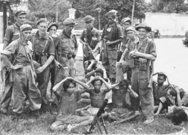 Nederlandse soldaten richten nonchalant hun wapens op soldaten van het Indonesische regeringsleger die zich hebben overgegeven. Solo, Midden-Java, 21 december 1948.