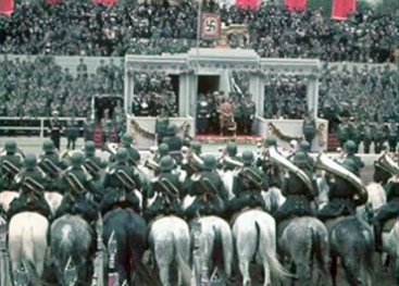 Massabijeenkomst van nazi's met Hitler. Het hakenkruis is overal te zien. Het hakenkruis wordt een teken (symbool) voor onvrijheid, geweld en vernietiging van miljoenen mensenlevens.