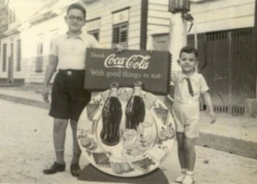 Jongens met een cola-reclamebord.