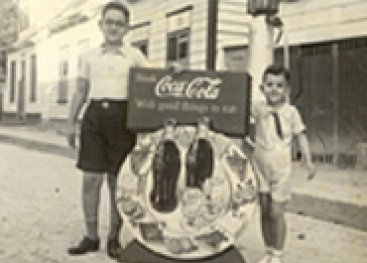 Jongens met een cola-reclamebord.