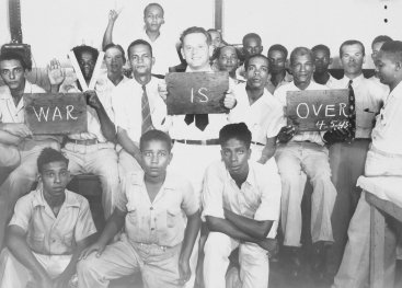 A group of young men holding signs: "War is over!".